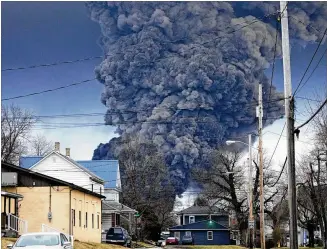  ?? GENE J. PUSKAR/ASSOCIATED PRESS ?? A black plume of smoke rises over East Palestine, Ohio, on Feb. 6 as a result of a controlled detonation of a portion of the derailed Norfolk Southern trains. Some nearby residents have sued the railroad and others have raised fears about long-term environmen­tal contaminat­ion.