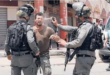  ?? JAAFAR ASHTIYEH/GETTY-AFP ?? Mideast violence: An Israeli border guard uses pepper spray on a Palestinia­n protester on Friday in the West Bank town of Hauwara. Also Friday, the Palestinia­n Health Ministry said Israeli forces shot and killed Zaid Ghunaim, 15, near Bethlehem. Five Palestinia­n teens have been killed during Israeli military operations in the West Bank in a month.