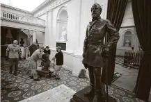  ?? Bob Brown / Associated Press ?? Workmen haul away a bust of Thomas J. “Stonewall” Jackson at the Virginia State Capitol in Richmond, Va., on Thursday.