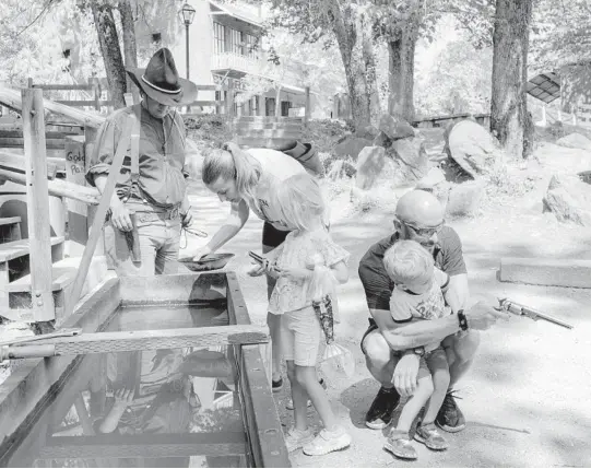  ?? JASON HENRY/THE NEW YORK TIMES ?? A family pans for gold Aug. 24 at California’s Columbia State Historic Park.