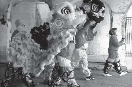  ?? ABEL URIBE/CHICAGO TRIBUNE ?? Performers wear masks as they march in the Argyle Lunar New Year Parade on Saturday in Chicago. A new virus has sickened thousands in China.