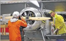  ??  ?? Don Popp (left) photograph­s the engine and propeller of a 7/8 scale replica of a WWI era Nieuport 23 as FAA representa­tive Terry Taylor inspects the biplane at the National Museum of the U.S. Air Force.