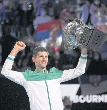  ?? AFP ?? Novak Djokovic celebrates with the trophy after winning the Australian Open title last month.