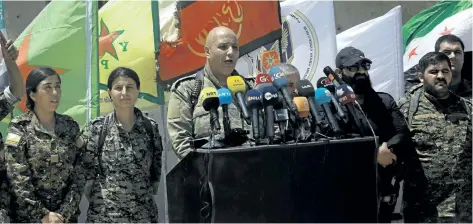  ?? DELIL SOULEIMAN/GETTY IMAGES ?? Talal Sillo, centre, spokesman for the U.S.-backed Syrian Democratic Forces gives a speech as SDF commander Rojda Felat, second from left, and other fighters listen on in the village of Hazima on the northern outskirts of Raqqa.