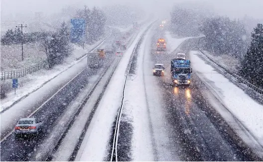  ?? ?? Slow going: Drivers battled wintry conditions yesterday morning as they negotiated the M74 near Abington, Lanarkshir­e