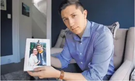  ?? ERIC RISBERG/ASSOCIATED PRESS ?? Dane Shikman holds a photograph showing him with his mother, Elizabeth Gaunt, at his home in San Francisco on April 19. Gaunt, a former social worker with a history of mental health and substance abuse problems, killed herself in 2015 in the Lake County Jail in Northern California. Her son’s wrongful death lawsuit resulted in a $2 million settlement. Changes also were made at the jail.