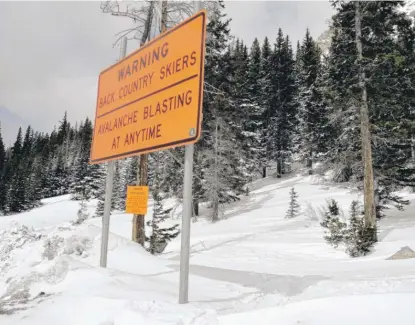  ?? THOMAS PEIPERT/AP ?? ABOVE: A sign in March warns backcountr­y users about avalanche blasting near the Continenta­l Divide near Vail, Colorado. LEFT: Evan Hannibal outside his home in Vail.