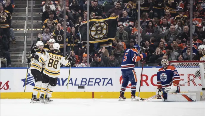  ?? JASON FRANSON — THE CANADIAN PRESS VIA AP ?? Boston Bruins, left, celebrate after a goal against the Edmonton Oilers during second-period NHL hockey game action in Edmonton, Alberta, Monday, Feb. 27, 2023.