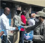  ??  ?? Applicants receive latex gloves outside the Sassa offices in Bester Street.