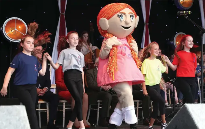  ??  ?? Ashling, the Fleadh mascot, leads the dancing on the gig rig at the opening of the Fleadh Cheoil na hEireann on Sunday at Bolton Square.