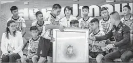  ?? LINH PHAM/GETTY ?? Boys from the Thai soccer team and their coach pay tribute during their first news conference to ex-SEAL diver Saman Gunan, who died during the rescue operation.