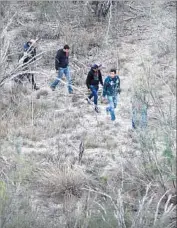  ?? John Moore Getty Images ?? IMMIGRANTS WALK along a path near the U.S.Mexico border outside La Grulla, Texas.