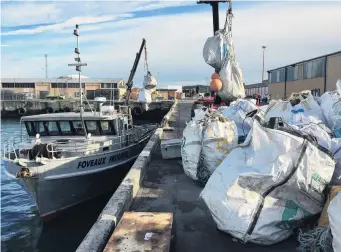  ?? PHOTO: JOHAN GROTERS ?? Heavy haul . . . Bags of rubbish are unloaded in Bluff after a Stewart Island beach cleanup.