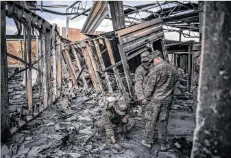  ?? Sergey Ponomarev / New York Times ?? U.S. military personnel on Jan. 13 survey the damage to Al Asad Air Base in Anbar, Iraq, which was struck by Iranian missiles a week earlier as vengeance for the killing of Qassem Soleimani.