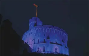 ??  ?? The Round Tower at Windsor Castle, where Queen Elizabeth is living due to the coronaviru­s pandemic, is pictured illuminate­d blue late on Friday to mark the 72nd anniversar­y of the NHS today.