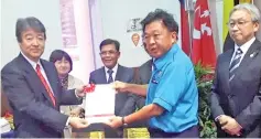  ??  ?? Yeo (right) and Dr Akifumi holding the Guidelines on Household Waste Segregatio­n and Collection in Kota Kinabalu, witnessed by Arifin (centre).