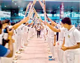  ??  ?? Above: Test cricketer G. H. Vihari makes his way out under an arch of bats held up by budding cricketers upon his arrival from England at the Hyderabad airport.