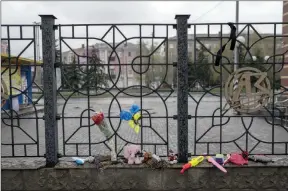  ?? The Associated Press ?? Flowers and toys were left on a fence at the railway station after a missile strike killed at least 59 people and wounded dozens more when a rocket hit the railway station in Kramatorsk, Ukraine.