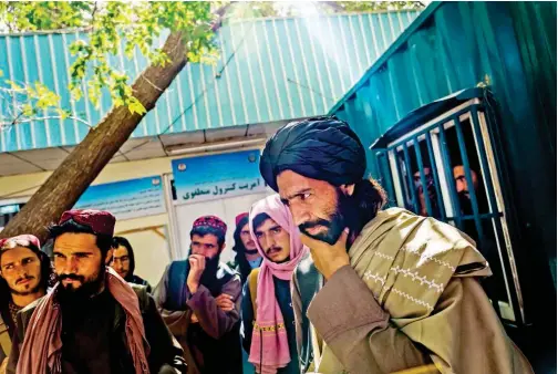  ?? File/tribune News Service ?? Mawlawi Shaker ( far right) the new chief of this city’s Police District 10, listens to the plight of a passerby at PD10 in Kabul, Afghanista­n.