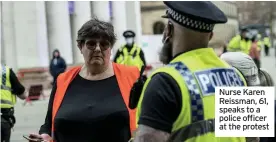  ??  ?? Nurse Karen Reissman, 61, speaks to a police officer at the protest