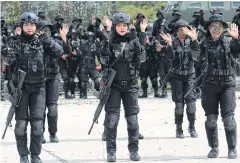  ??  ?? ABOVE Female soldiers perform a drill during a show to forge closer community relations in Pattani.