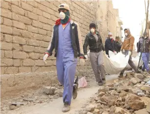  ?? Reuters) ?? LOCAL RESIDENTS carry bodies taken from the rubble in the Old City of Mosul last month.