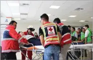  ?? AP PHOTO BY RED CROSS DURANGO ?? In this photo released by Red Cross Durango communicat­ions office, Red Cross workers attend airline passengers who survived a plane crash, at a medical center in Durango, Mexico, Tuesday, July 31.