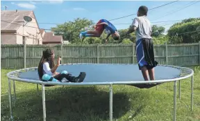  ??  ?? Jermarria, Jermarkus and Kendall play on the backyard trampoline.