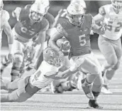  ?? CHARLES TRAINOR JR./MIAMI HERALD ?? St. Thomas Aquinas’ Daniel Carter (5) runs for a firstquart­er touchdown as he breaks the tackle of Venice’s Rowan Foskin in the Raiders’ 38-18 victory Friday night.