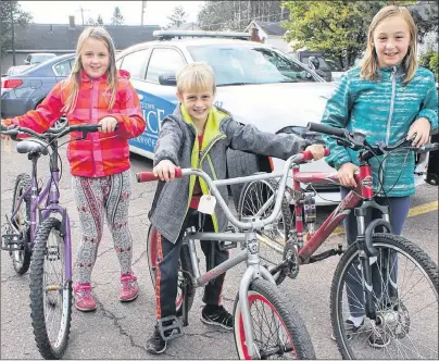  ?? MITCH MACDONALD/THE GUARDIAN ?? Siblings, from left, Erika, Reese and Jordan Kennedy show the bikes their father Thane bought them during the Charlottet­own Police bike auction on Saturday. Reese was also celebratin­g his eighth birthday on the day of the auction.