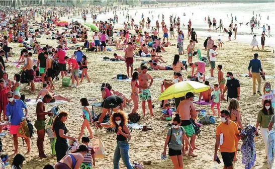  ?? REUTERS ?? Centenares de personas disfrutan del sol en la playa de La Concha, en San Sebastián