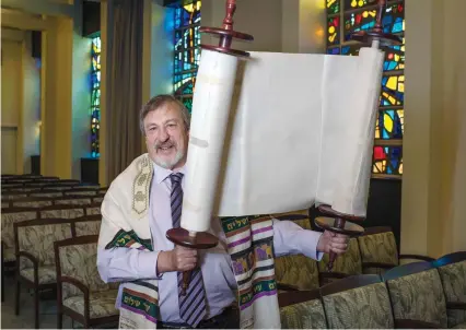  ??  ?? RABBI LENNY SARKO holds a Braille Sefer Torah earlier this month at Congregati­on Emanu-El Israel in Greensburg, Pennsylvan­ia. (Pittsburgh Post-Gazette/TNS)