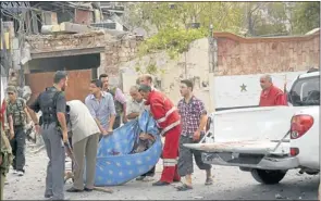  ?? Picture: REUTERS ?? BEREAVED: Men prepare to carry away a victim in a blanket after blasts ripped through Aleppo’s main Saadallah alJabiri Square, in Syria, yesterday.