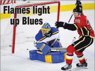  ?? CP PHOTO JEFF MCINTOSH ?? St. Louis Blues goalie Jake Allen, left, looks back as Calgary Flames' Curtis Lazar celebrates his team's goal during third period NHL hockey action in Calgary Monday.