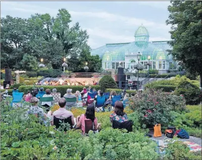  ?? [RICK BUCHANAN] ?? Audience members enjoy an outdoor performanc­e by ProMusica Chamber Orchestra at Franklin Park Conservato­ry and Botanical Gardens