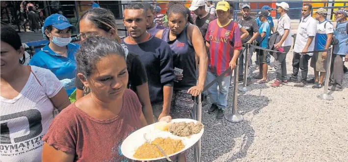  ?? EFE ?? A comer. Miles de venezolano­s forman fila por comida en el comedor comunitari­o Divina Providenci­a, en Cúcuta. Maduro prohibió el ingreso de ayuda humanitari­a a su país.