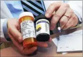  ?? NEW HAVEN REGISTER FILE PHOTO ?? Pharmacist Nicholas Tamborrino, owner of Bluepoint Wellness of Connecticu­t in Branford, shows a sample of a medical marijuana prescripti­on in this 2016 file photo.