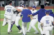  ?? Tom Pennington / Getty Images ?? The Dodgers’ Austin Barnes, second from left, and Julio Urias, third from left, celebrate with teammates on the field after clinching the World Series over the Rays on Tuesday at Globe Life Field in Arlington, Texas.