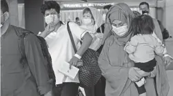  ?? JOSE LUIS MAGANA/AP ?? Families evacuated from Kabul, Afghanista­n, walk through Washington Dulles Internatio­nal Airport in Chantilly, Va., on Tuesday.