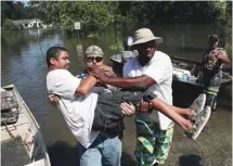  ?? JOE RAEDLE GETTY IMAGES ?? Quintin Sanders est secouru par ses voisins après que son quartier de Beaumont, une ville du Texas, a été inondé par la tempête Harvey.