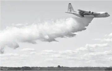  ??  ?? A New South Wales Rural Fire Services Hurcules C-130 plane drops water in an exercise at the Royal Australian Airforce base in Richmond. — AFP photo