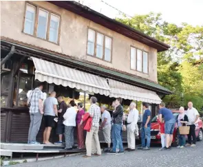  ??  ?? People queue up to buy somun, a local staple.