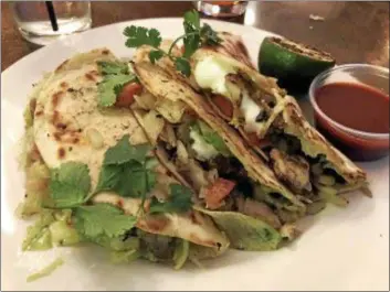  ?? MARK MESZOROS — THE NEWS-HERALD ?? 2nd and High Social House’s Blackened Fish Tacos are made with tilapia and also feature lettuce, pico de gallo and crema.
