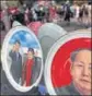  ?? AFP ?? A Tiananmen Square shop with plates featuring President Xi Jinping and his wife, and former leader Mao Zedong.