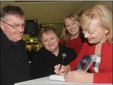  ??  ?? Deirdre McArdle-Clinton signing a Book for Tommy McGuinness, watched by Maisie McGuinness and Donna Sweeney at the official launch of Deirdre McArdle-Clinton and Pat Clinton’s Book ‘Jewel of The North East’ Documentin­g the Story of DkIT 1969-2016 held in The Dundalk Institute of Technology.