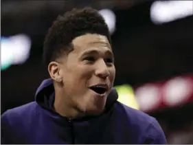  ?? AP PHOTO/ TONY GUTIERREZ ?? Phoenix Suns guard Devin Booker laughs with teammates on the bench after a score against the Dallas Mavericks during the second half of an NBA basketball game in Dallas, on Tuesday. For the eighth season in a row, the Suns won’t make the playoffs....