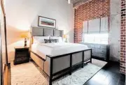  ??  ?? Above: Soft rugs and bedding add a bit of warmth to Steve Johnston’s master bedroom. Though the room is somewhat small, a 75-inch square mirror leaning against the wall opposite the window reflects natural light, making the space feel bigger and...