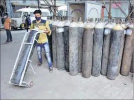  ?? PRAFUL GANGURDE/HT PHOTO ?? A civic hospital staffer carry an oxygen cylinder for Covid-19 patients amid an unpreceden­ted surge in coronaviru­s disease cases, in Thane on Thursday.