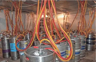  ?? PHOTOS BY JULIA MARTINS DE SA / MILWAUKEE JOURNAL SENTINEL ?? The cooler of beer kegs fills Sugar Maple on July 13. The bar has 60 tap lines, most of which are for beer.