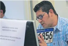  ?? FOTO: M. CUBAS. ?? DEMANDA. Un empleado del IP verifica en el sistema una placa antes de entregarla. Unas 400 personas llegan al día.